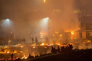 Huge fire destroys refugee camp in northern France after clashes
